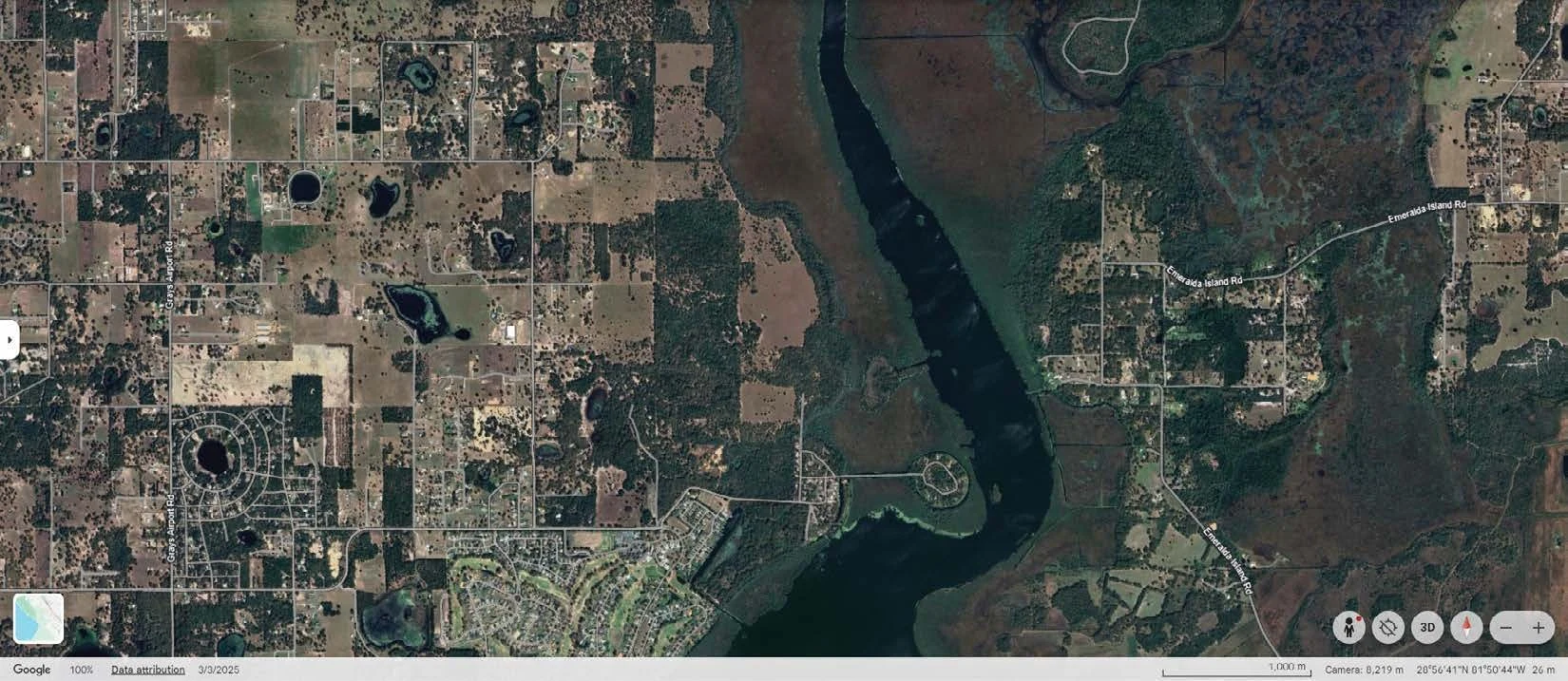 Reference aerial showing an outlined land area beside waterways and neighboring communities